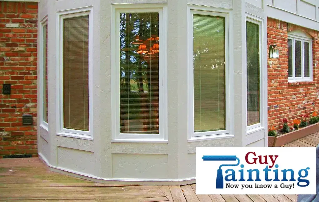 Bay window with restored wood and crisp white paint after Guy Painting repair