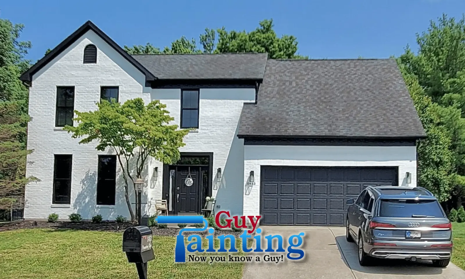 A stunning "After" transformation of a modern farmhouse-style residence, providing a prime example of high-quality home exterior painting near me in Geist. The Guy Painting team converted the original brick and siding into a brilliant, solid white, creating a sharp architectural contrast with the deep black trim, gutters, and window frames. The project is completed with a matching black garage door and front entryway, significantly increasing the property's value and aesthetic. This full-scale makeover by Guy Painting showcases the dramatic curb appeal possible with a professional white-painted brick and dark-trim color scheme.