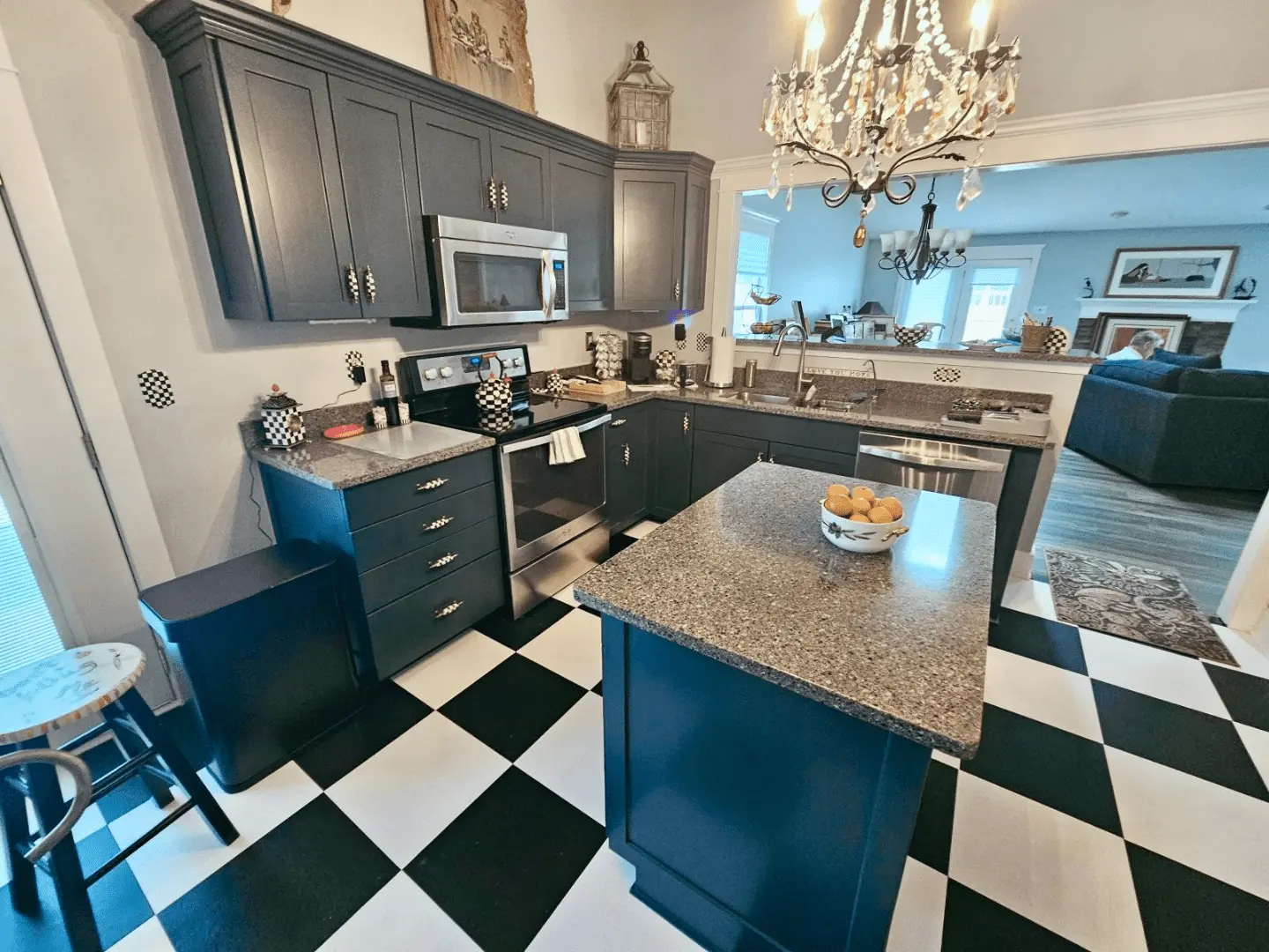 A stunning kitchen renovation featuring a bold sapphire blue finish on the island and perimeter units. This project is a centerpiece of our cabinet painting Indianapolis services in Geist. Guy Painting provides high-quality coatings that transform dated wood into a modern lake house aesthetic, complemented by a classic black-and-white checkered floor and granite countertops for a completely refreshed culinary space.